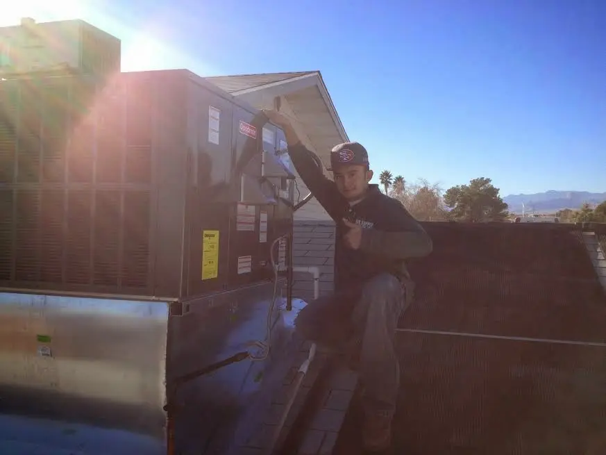 HVAC technician performing Heat Pump Repair on a rooftop unit in Lakes of the Four Seasons